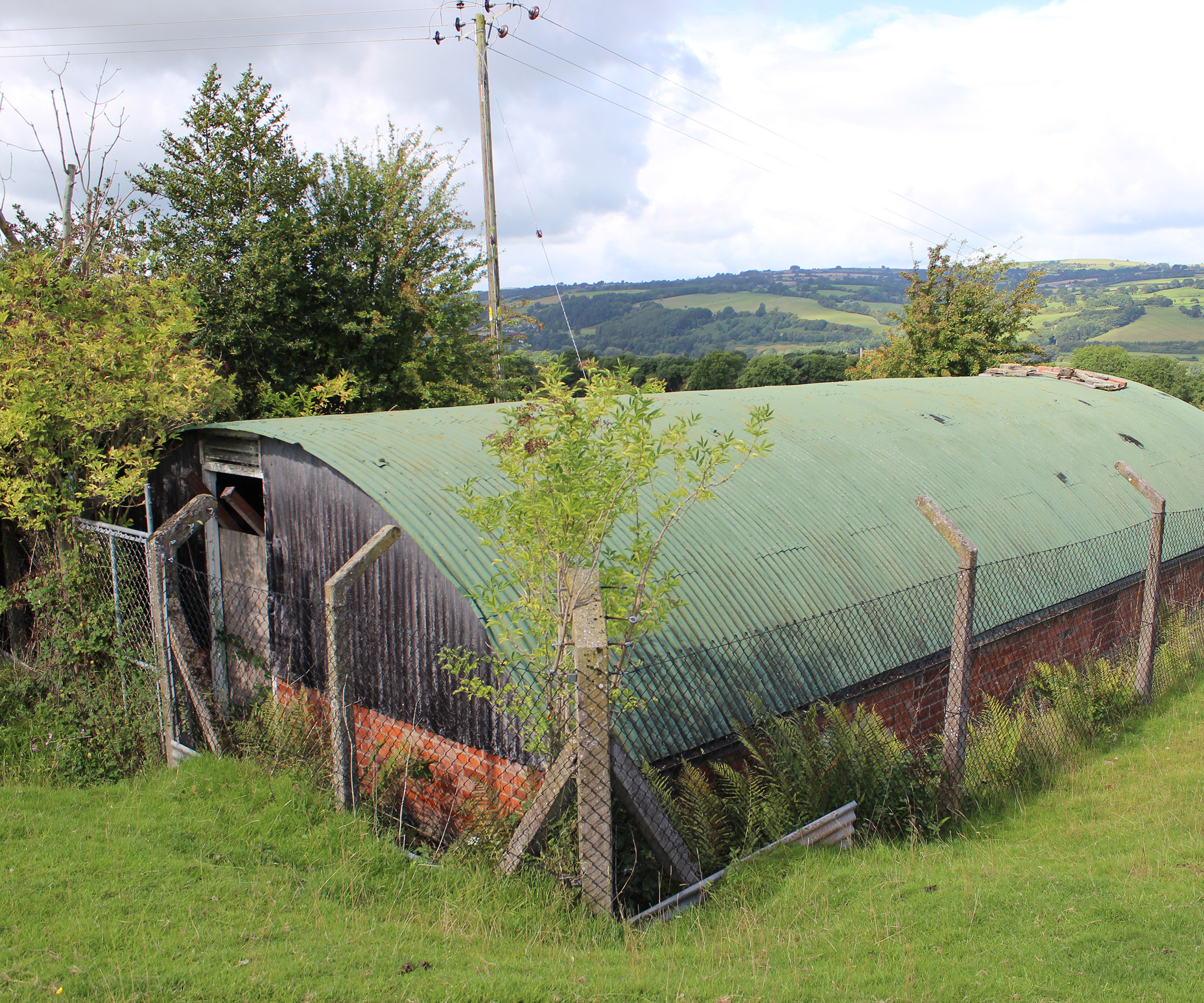 Old corrugated metal building set in the hills before a complete conversion